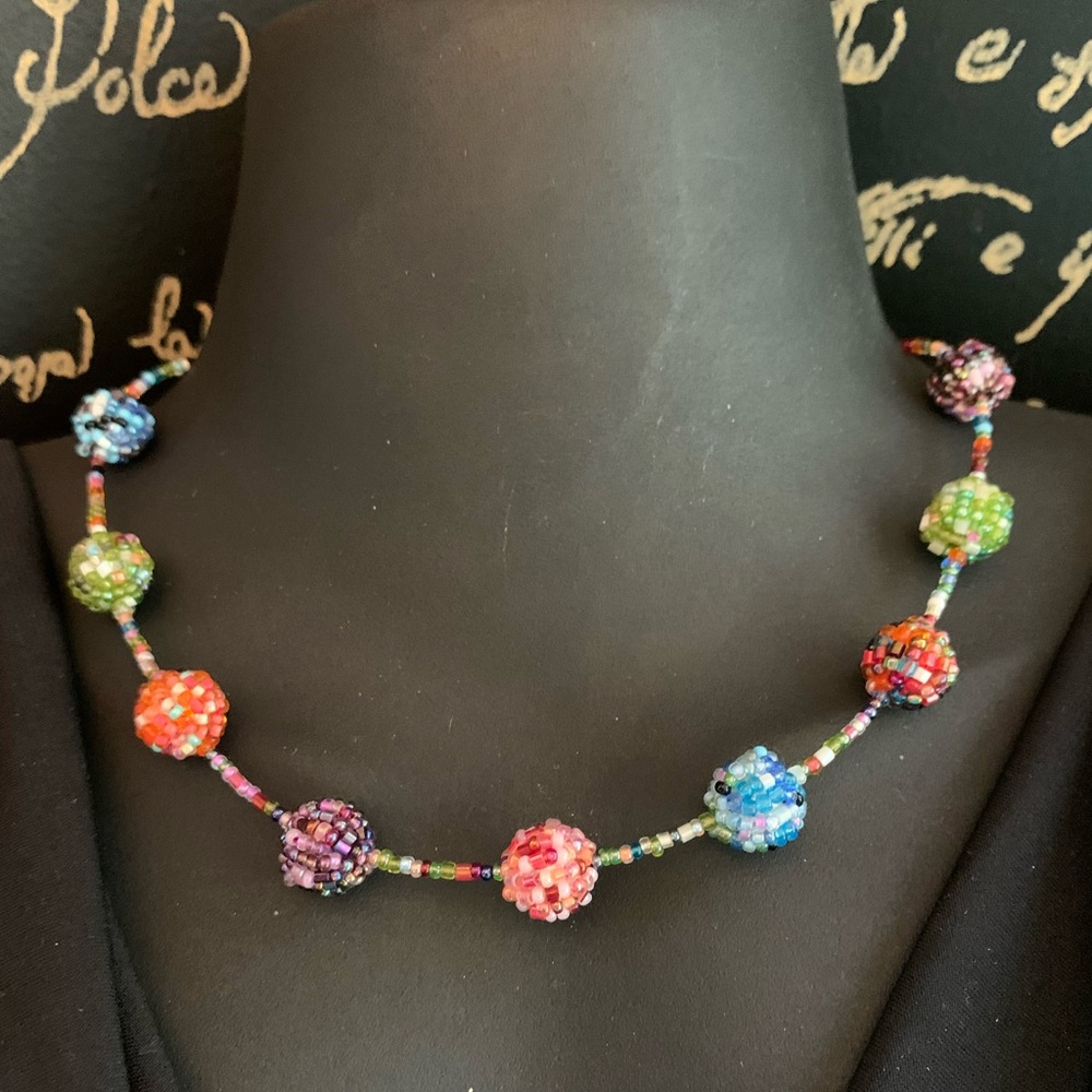 Multicolored beads stationed around necklace with additional chain for length
